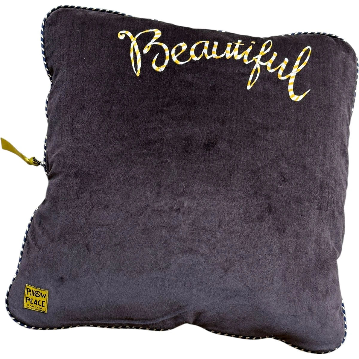 Black pillow with 'Beautiful' text in gold on a white background