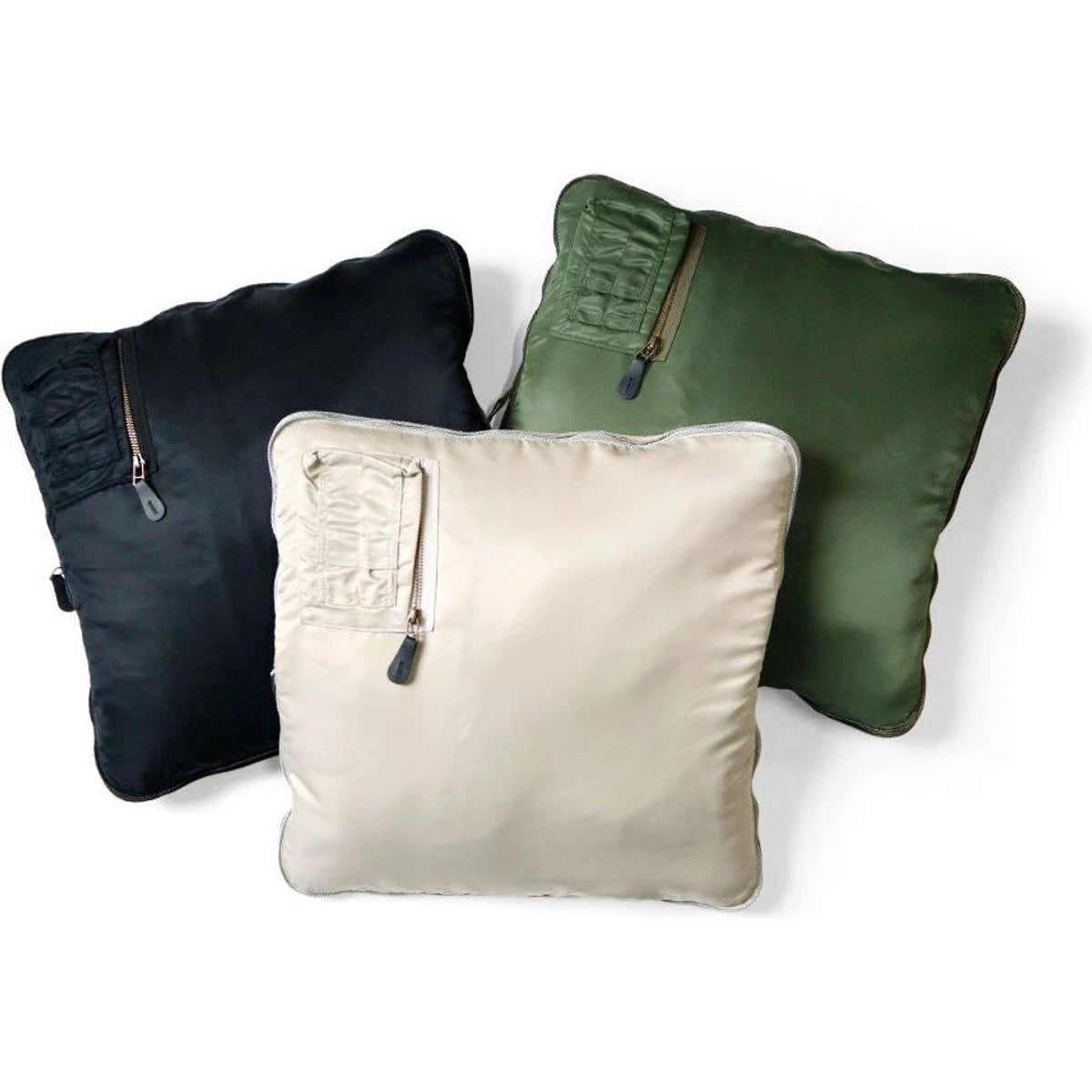 Three pillows in black, green, and beige with zipper details on a white background
